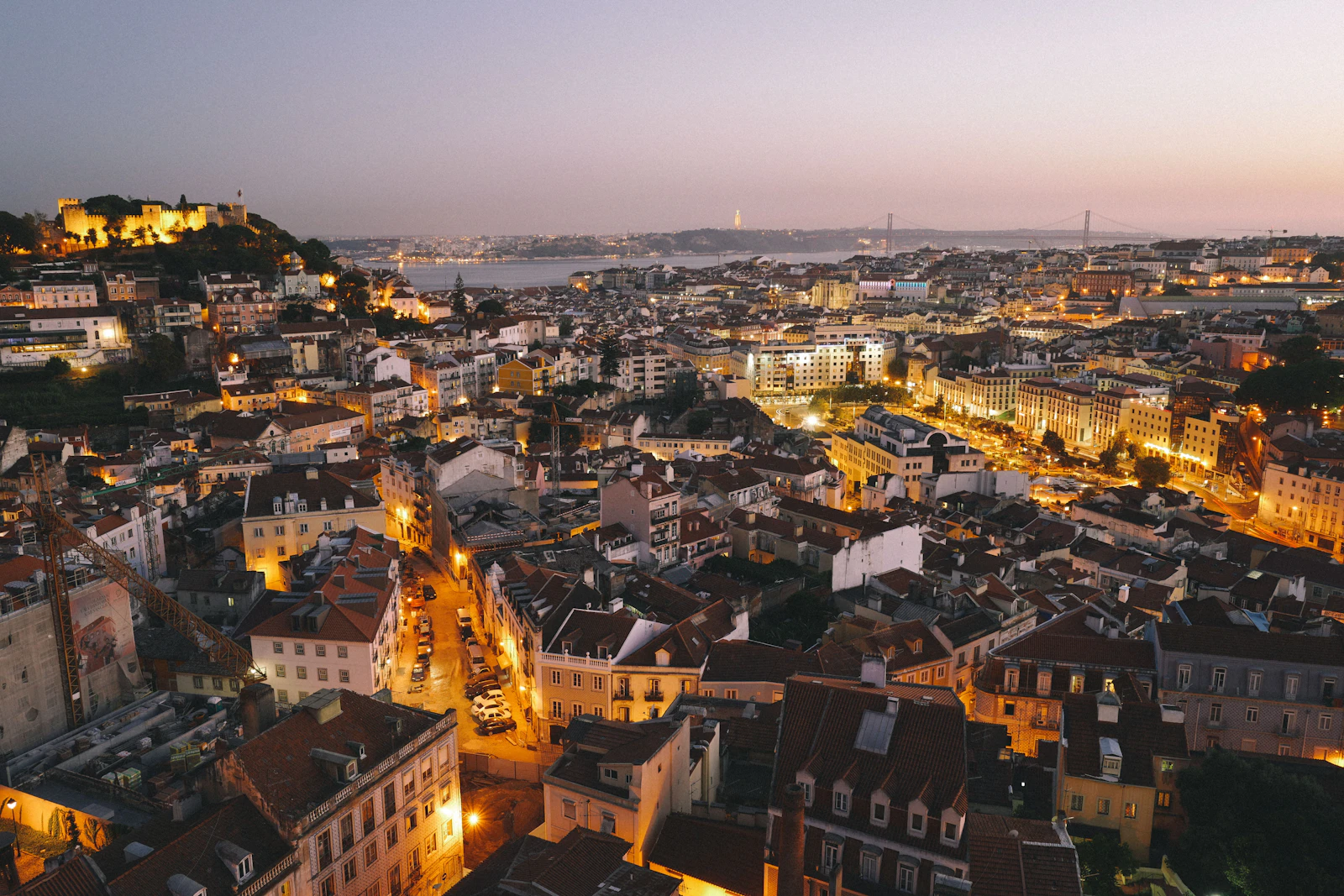 Lisbon cityscape at dusk with rooftops and river